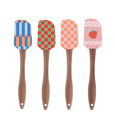 Four colorful spatulas with patterned heads on wooden handles against a white background
